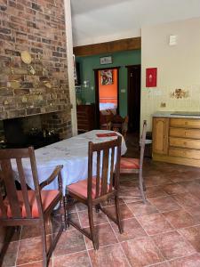 a dining room with a table and chairs and a fireplace at Marnwood Lodge in Coalbrookdale +3 photos