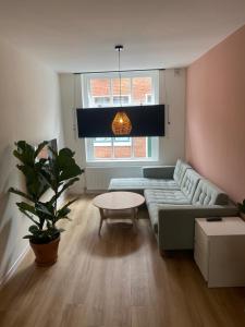 a living room with a couch and a table at Hotel 't Fnidsen in Alkmaar