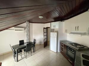 a kitchen and dining room with a table and chairs at Appartement spacieux à Nongo,UNC in Nongo