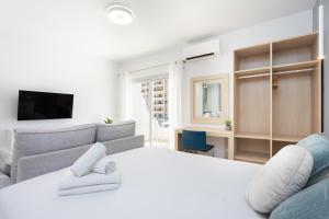 a bedroom with a white bed and a couch at Estudio Paraiso del Sur in Playa Paraiso +23 photos