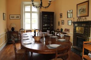a dining room with a table and a fireplace at Beau château entre Loire et Bourgogne, 12 chambres 27 personnes in Saint-Doulchard
