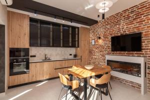 una cucina con muro di mattoni e tavolo e sedie in legno di LEOGRAND Jacuzzi on Krakivska 26 a Lviv