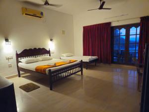 a bedroom with two beds and a large window at Orion Seaview Beach Hotel in Kovalam
