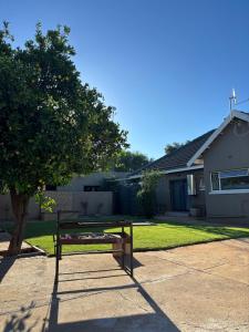 a bench sitting in front of a house at Carstens Garden Cottages in Kimberley