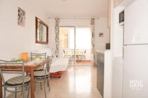 a kitchen and dining room with a table and a refrigerator at Apartamento Marina Dreams in Roses +17 photos