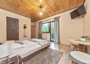 a bedroom with a large bed and a table at Pokoje Gościnne Perła in Brenna
