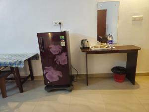 a small refrigerator next to a table and a table at Orion Seaview Beach Hotel in Kovalam +43 photos