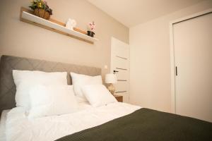 a bedroom with a bed with white pillows at Apartament Bellissima in Bielsko-Biala