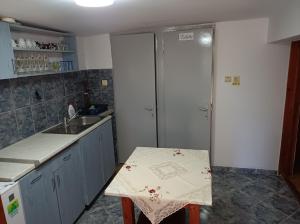 a kitchen with a sink and a table in it at Gyongyver Panzio in Sfântu-Gheorghe