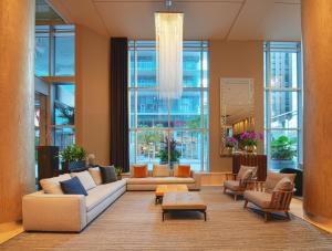 a lobby with couches and chairs and windows at Warwick Le Crystal - Montréal in Montreal