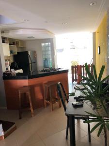 a kitchen with a bar and a table and chairs at Paraíso na cidade in Salvador