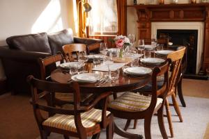 a dining room with a table and chairs and a fireplace at Ardchoile in Kingussie