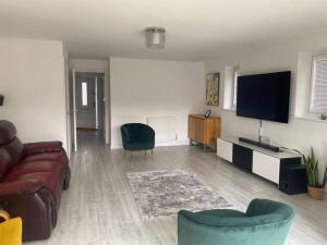a living room with a couch and a flat screen tv at Liddle Way Garden Getaway in Basingstoke