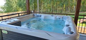 a hot tub on a deck with a fence at Arizona Ranch in Râșca