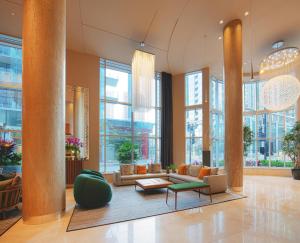 a lobby with a couch and chairs in a building at Warwick Le Crystal - Montréal in Montreal
