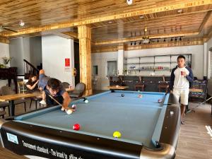 a group of people playing a game of pool at Pea Hostel in Sa Pa