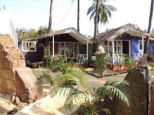 a blue house with palm trees in front of it at Sea Shades Palolem Resort in Palolem +33 photos