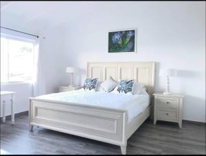 a white bedroom with a large white bed with pillows at Dickenson Bay Oasis at Antigua Village in Saint Johnʼs +23 photos