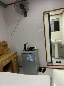 ハノイにあるAsia Cozy Houseの冷蔵庫、洗面台、扇風機付きのバスルーム