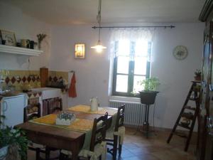 une cuisine avec une table et des chaises ainsi qu'une fenêtre dans l'établissement Chambre d'hôtes La Margotte, à Forcalquier