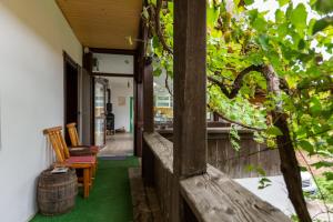 a porch of a house with chairs and a barrel at WineHouse38 - Chardonnay Room in Jidvei