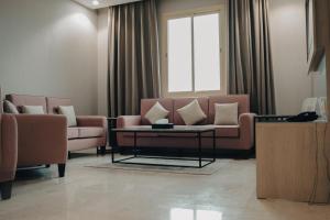 a living room with two couches and a table at Armada Residence Hotel in Taif