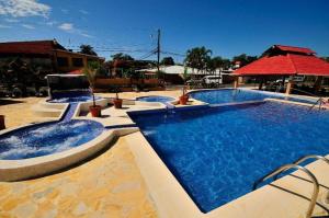 a large swimming pool with two jacuzzi at In the HEART of Jaco at Villas Paraiso in Jacó
