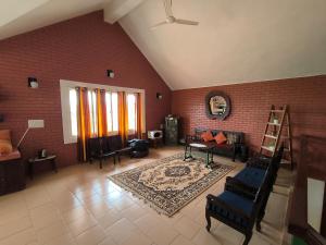 a large living room with a brick wall at Nestinggrounds in Mudigere