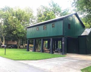 a green house with a green roof on a grass field at Highbridge River Cabin in Wilmore