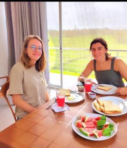 two women sitting at a table with a plate of food at Ela addara Home stay in Lukasgoda