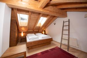 a attic room with a bed and a ladder at Almhäuser Filzsteinalpe Almhaus 196 in Krimml