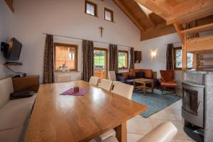 a dining room with a table and a living room at Almhäuser Filzsteinalpe Almhaus 196 in Krimml