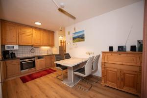 een keuken met houten kasten en een tafel en stoelen bij Chalet Alpine Royal B Top 20 in Krimml