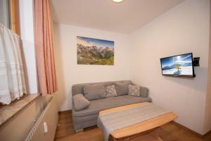 een woonkamer met een bank en een tafel bij Chalet Alpine Royal B Top 20 in Krimml