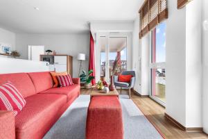 a living room with a red couch and a red rug at Ferienwohnung Meermarie Olpenitz in Olpenitz