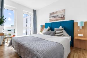 a bedroom with a large bed with a blue headboard at Ferienwohnung Meermarie Olpenitz in Olpenitz
