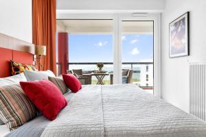 a bedroom with a large bed with red pillows at Ferienwohnung Meermarie Olpenitz in Olpenitz