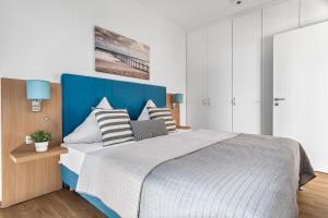 a bedroom with a large bed with a blue headboard at Ferienwohnung Meermarie Olpenitz in Olpenitz +30 photos