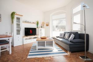 Una sala de estar con un sofá y un televisor. en Fewo Meerluft nur wenige Minuten vom Hafen und Strand entfernt, en Laboe