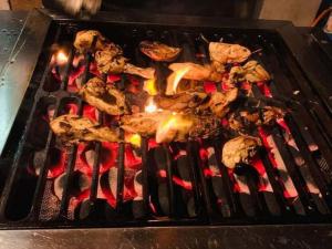 a bunch of food cooking on a grill at Ela addara Home stay in Lukasgoda
