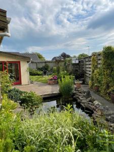 a garden with a pond in a yard at Naturlig Ro in Aalborg