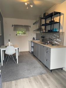 una cucina con un lavandino, una scrivania e un tavolo di Small cozy apartment a Tromsø Altre 7 foto