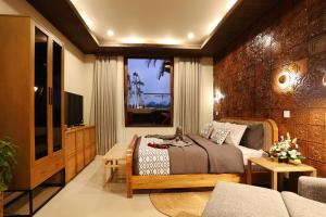 ウルワツにあるHomeSix Terakota Baliの大きなベッドとテレビのある寝室