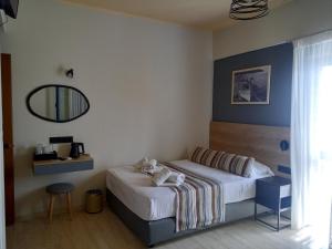 a hotel room with a bed and a mirror at Horizon Beach Hotel in Plakias