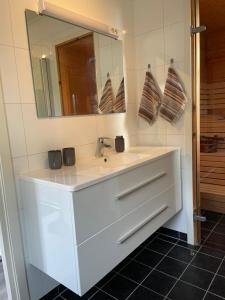 un bagno con un lavandino bianco e uno specchio di Small cozy apartment a Tromsø