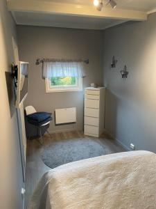 una camera da letto con un letto, un comò e una finestra di Small cozy apartment a Tromsø