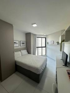 a bedroom with a bed and a desk with a computer at Flat em Boa Viagem Recife PE in Recife +6 photos