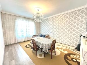 Un comedor con una mesa y sillas y una lámpara de araña. en Badamdar Sea View, en Baku