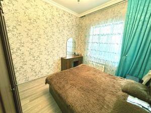 1 dormitorio con 1 cama con cortinas azules y espejo en Badamdar Sea View, en Baku