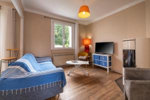 a bedroom with a bed and a tv and a desk at Maison de vacances 50m de la plage in Larmor-Plage